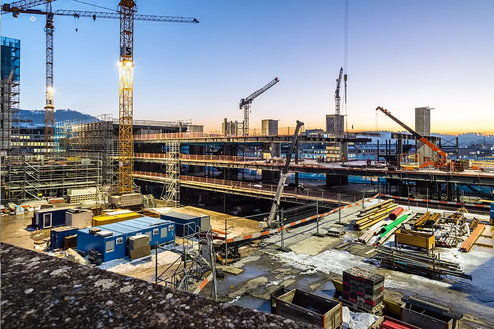 Großbaustelle mit Kränen in der Abenddämmerung