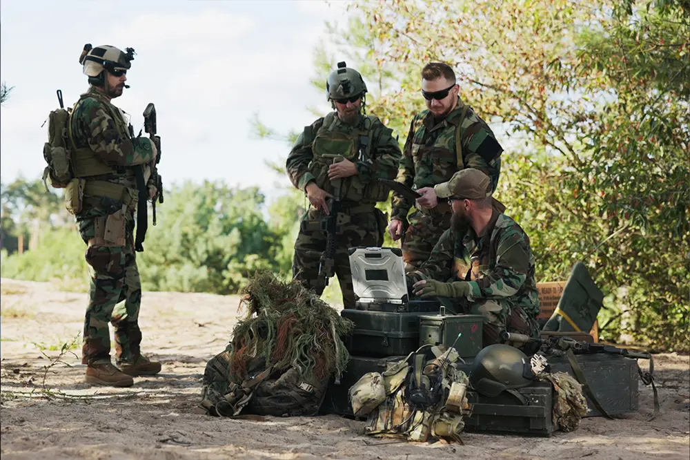 Soldaten mit Ausrüstung und Funkgerät im Gelände