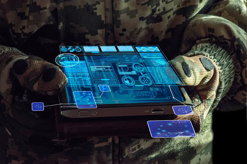 Hände in Tarnkleidung halten ein Tablet mit eingeblendeter Lagekarte
