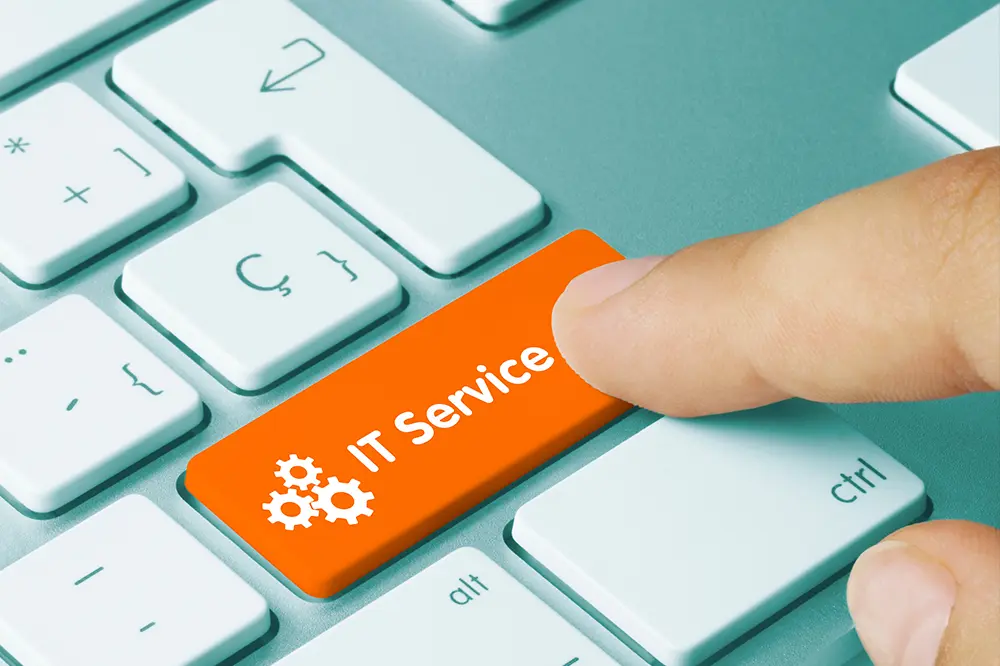 Finger drückt eine orange Taste mit der Aufschrift IT Service