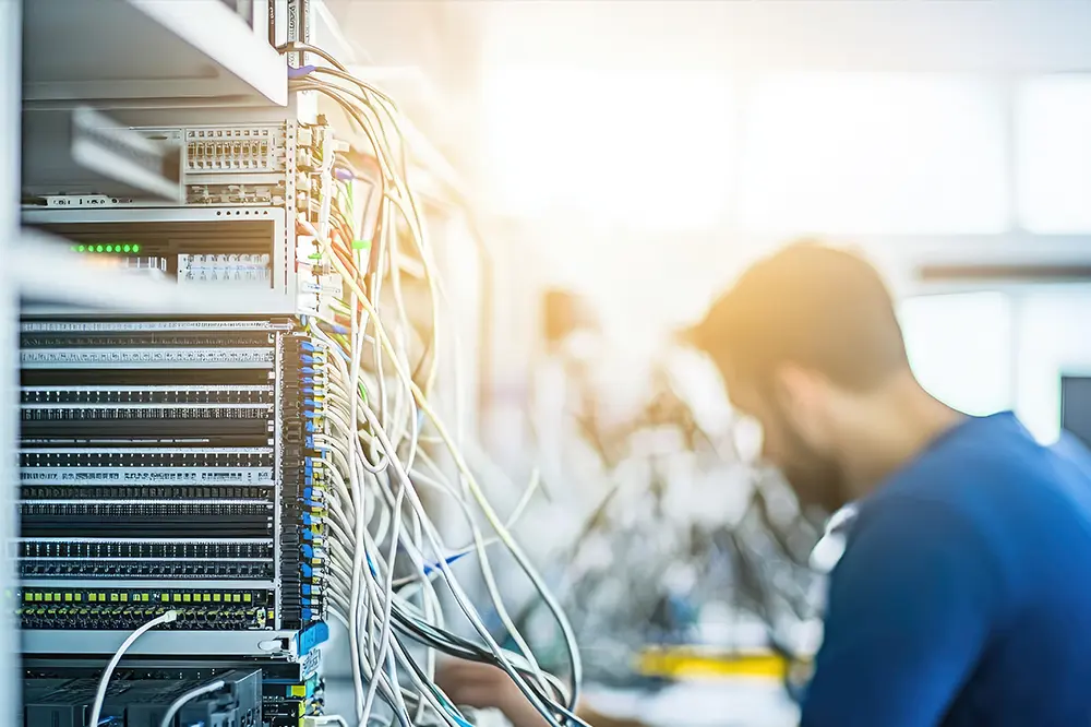 Techniker verkabelt einen Netzwerkschrank im Serverraum