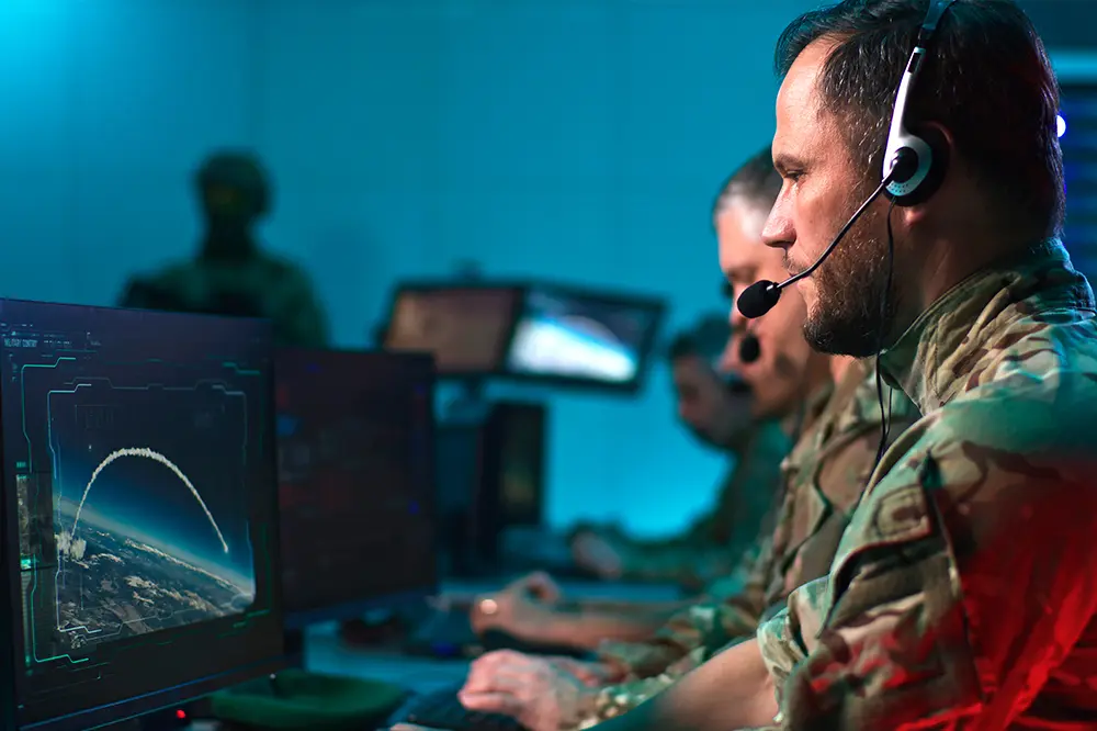 Soldaten mit Headsets an Bildschirmen in einem Lagezentrum