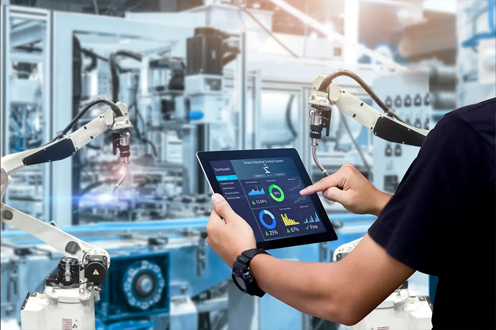 Hand bedient ein Tablet mit Anlagendaten vor Industrierobotern