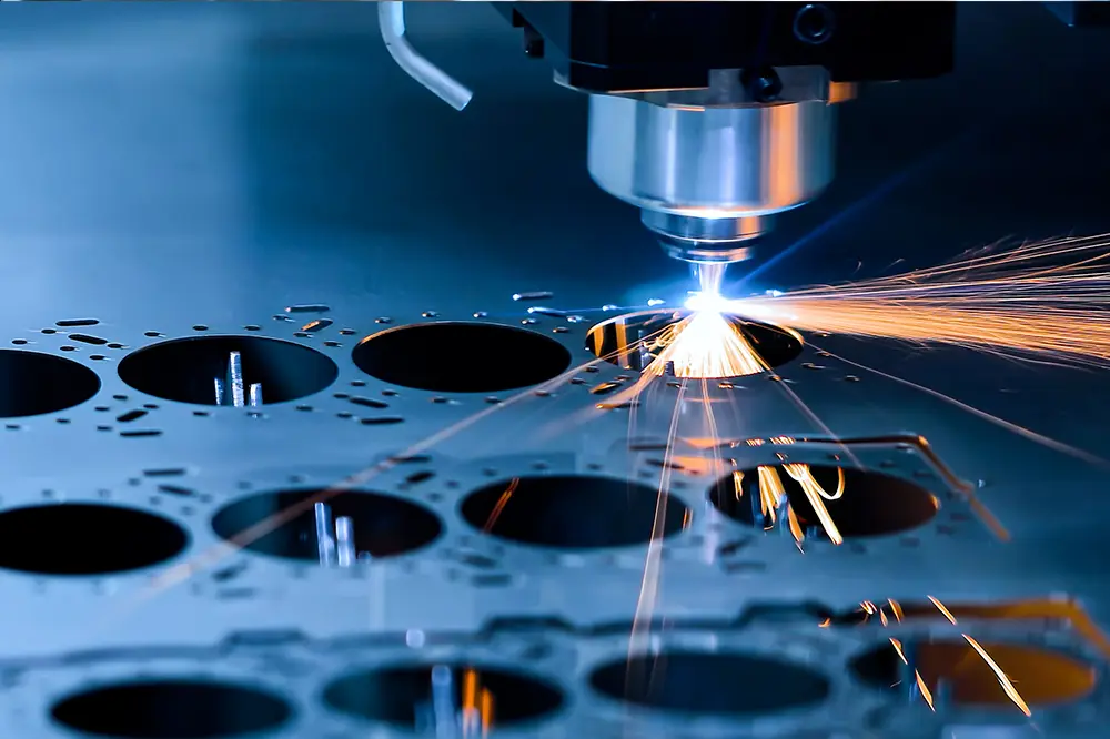 Laserschneider schneidet Löcher in eine Metallplatte, Funken sprühen
