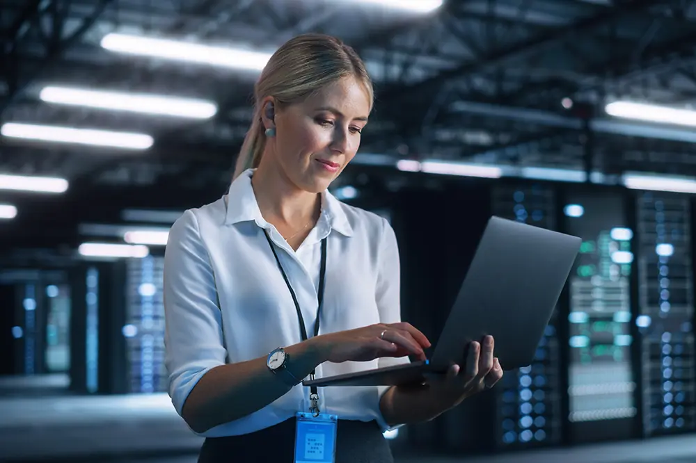 IT-Administratorin mit Laptop im Rechenzentrum
