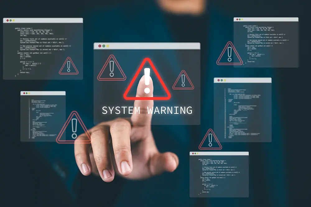 Finger tippt auf eine eingeblendete Systemwarnung mit Warndreiecken