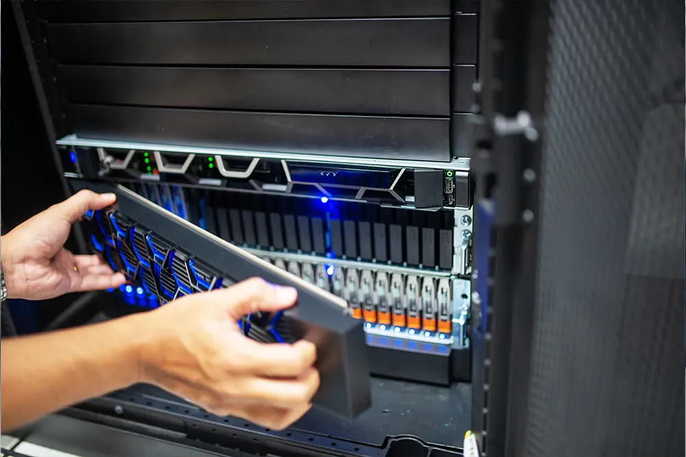 Hände setzen einen Server in ein Rack ein